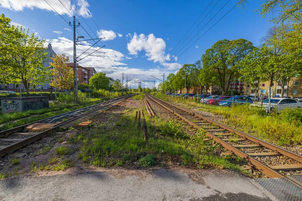フェンスで囲まれた街のダウンタウンで鉄道や車の駐車場のビュー スウェーデンだ ウプサラ — ストック写真