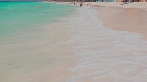 砂浜のイーグルビーチで太陽の傘の下でサンラウンジャーに横たわっている人々と大西洋の海の美しい景色 アルバだ オラニエスタッド 2023 — ストック動画