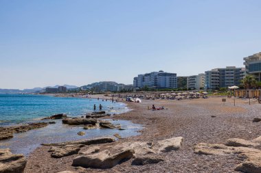 Güneşli bir günde sahildeki insanları ve arka plandaki yüksek binaları görmek. Rodos. Yunanistan. 