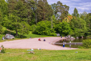 Yazın kumlu göl kıyısında yaşayan insanların olduğu güzel doğa manzarası. İsveç. Uppsala. 06.25.2022.