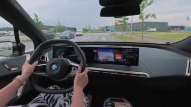 Otoyolda yeni BMW iX40 kullanan bir kadın. İsveç. Uppsala. 08.18.2022.