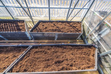 Baharda sebze dikmek için palet yakalı sera yataklarının manzarasını kapatın. İsveç.
