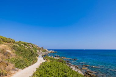 Rocky kıyı şeridi ve mavi su Akdeniz ufukta mavi gökyüzüne birleşiyor. Yunanistan. 
