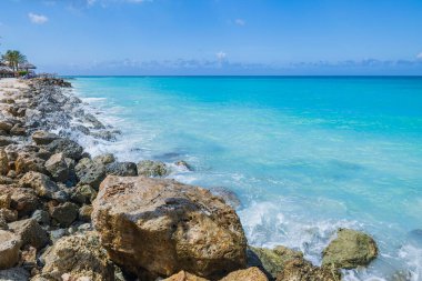 Atlantik Okyanusu 'nun güzel manzarası. Aruba adasında turkuaz su var. Kayalık kıyılarda dalgalar var..