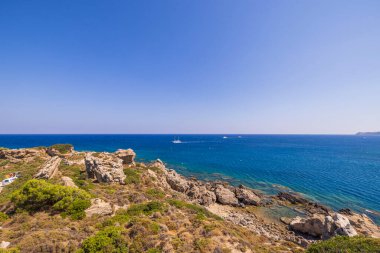 Akdeniz 'in dağdan mavi suyuna kadar güzel bir manzara ve yelkenli gemisi mesafesi. Rhodes Adası. Yunanistan.