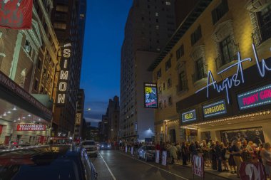 Broadway, Manhattan, New York 'taki August Wilson Tiyatrosu' ndaki ünlü müzikali izlemek için sırada bekleyenlerin akşam manzarası. ABD. 