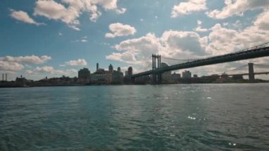 Manhattan gökdelenlerinin ve Brooklyn Köprüsü 'nün muhteşem manzarası beyaz bulutlu mavi gökyüzüne karşı. - New York. ABD.