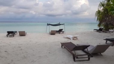 Şemsiye güneşli ve güneşli beyaz kumsal manzarası Maldivler 'de Hint Okyanusu' nun arka planına karşı..