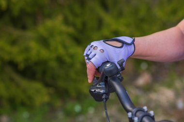 Bisiklet gidonunda spor eldivenli bir kadının el görüntüsü. İsveç. 