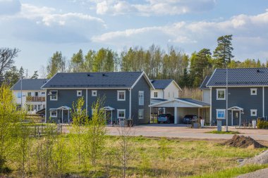 Ahşap gri villaları ve kasaba evleri olan modern Avrupa banliyölerinin güzel manzarası. Yeni modern evler. 