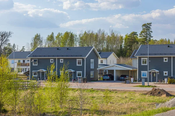 Ahşap gri villaları ve kasaba evleri olan modern Avrupa banliyölerinin güzel manzarası. Yeni modern evler. 