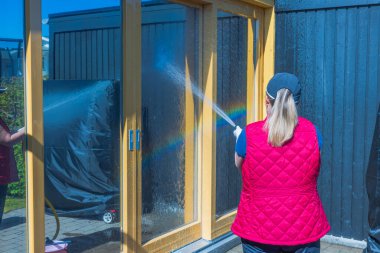 Yıkamadan önce pencereleri suyla kaplayan kadının görüntüsünü kapat. İsveç. 