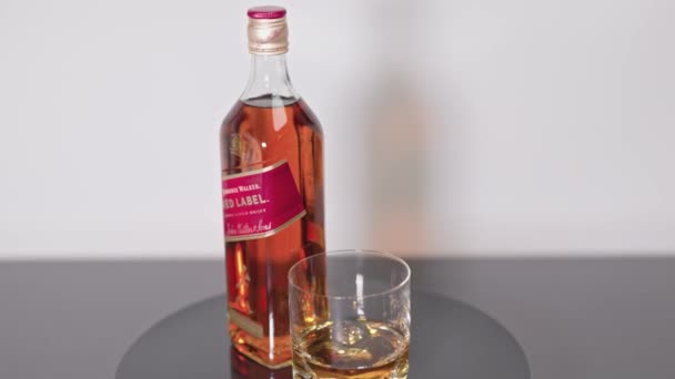 Vista Cerca Botella Giratoria Whisky Johnnie Walker Red Label Vaso — Vídeos de Stock