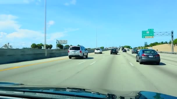柏油公路 车速快 蓝天上有绿色热带树木 背景为白云 迈阿密 佛罗里达 — 图库视频影像