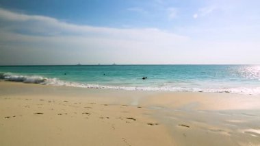 Atlantik Okyanusu 'nda gün batımının güzel manzarası. Kum Kartalı Sahili manzaralı. İnsanlar dalgaların arka planında banyo yapıyor. Aruba.
