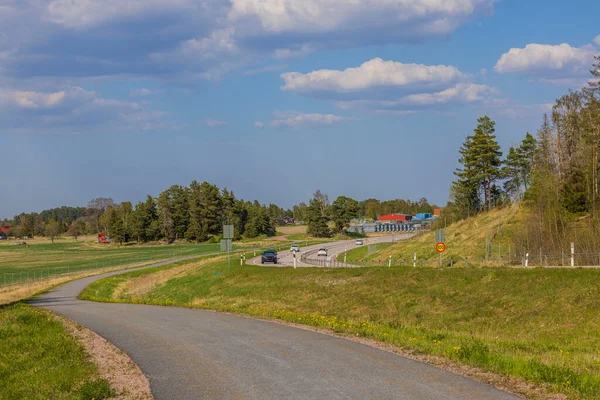 stock image Beautiful view of highway with cars and asphalt road for pedestrians and cyclists in countryside. Sweden. Europe.