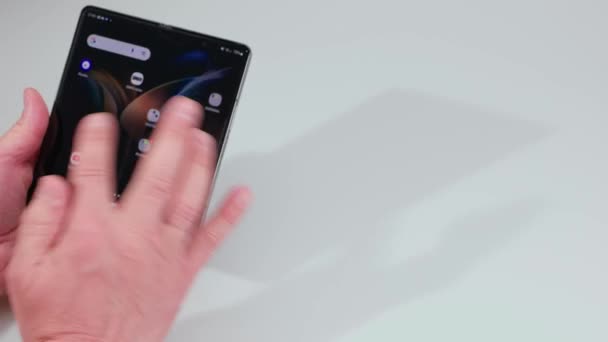 Man Surfing Στο Νέο Samsung Galaxy Fold Κινητό Τηλέφωνο Έννοια — Αρχείο Βίντεο