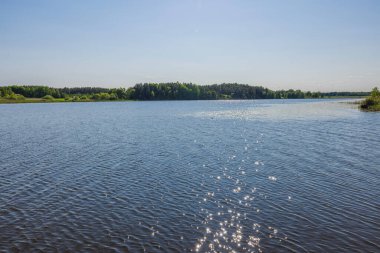 Gün batımındaki güzel göl manzarası. Sudaki güneş ışınlarının yansıması. İsveç