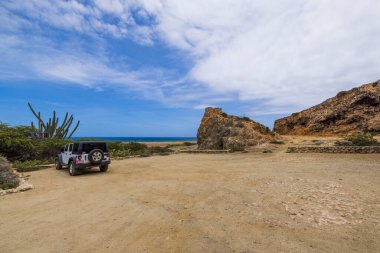 Karayip deniz kıyısındaki Quadirikiri Mağaraları 'na park edilmiş off-road aracı görüntüsü. Aruba. Oranjestad. 