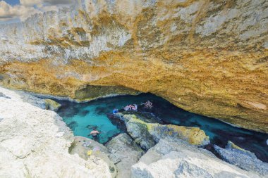 Aruba adasındaki Atlantik Okyanusu 'nun kayalıklarında doğal havuzda yıkanan bir grup insanın güzel manzarası. Oranjestad.