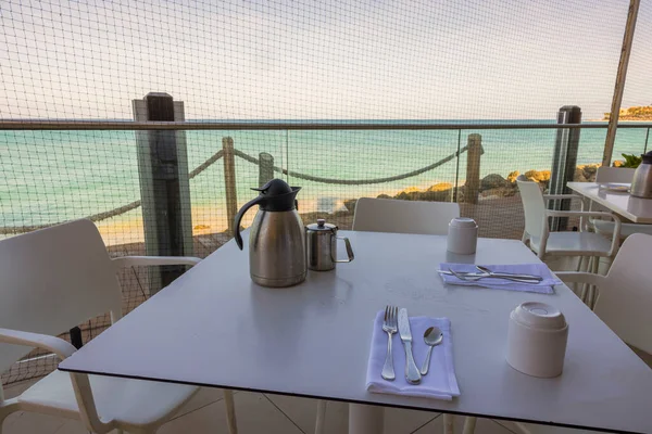 stock image Close-up view of table with cutlery for breakfast in open-air restaurant overlooking Atlantic Ocean. Aruba.