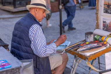 Eski ressam, güneşli bir yaz gününde Stockholm 'ün kentsel manzaralarını çiziyor. İsveç. Stockholm. 