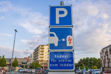 Alışveriş merkezinin yakınındaki otoparkta elektrikli araçları şarj etmek için kullanılan park yeri görüntüsü. İsveç.