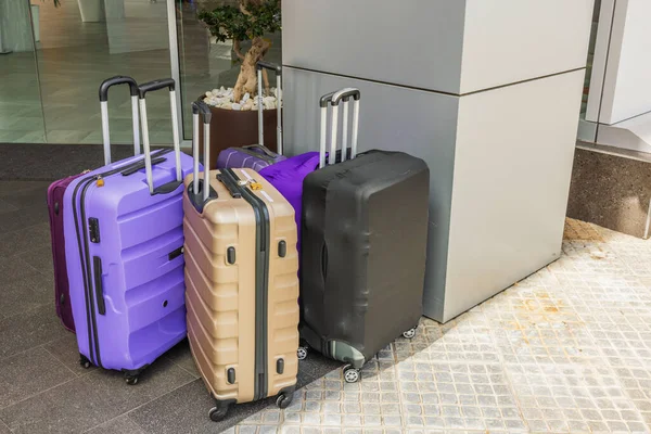 Close-up view of colorful suitcases near hotel entrance. Tourism and transportation concept. Spain.