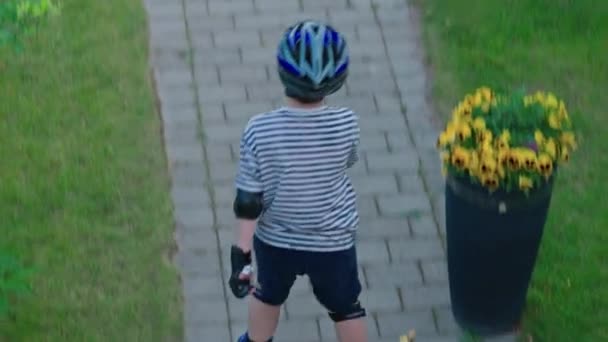 晴れた夏の日に庭でインラインスケートを学ぶ若い男の子のトップビュー スウェーデン — ストック動画
