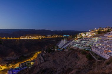 Gün batımında kayalık dağ manzarasında yer alan Gran Canaria otellerinin güzel manzarası. İspanya.