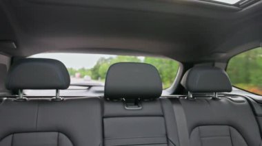 Otobanda yeni siyah elektrikli arabanın deri koltuklarıyla dikiz aynasından yakın çekim. İsveç.