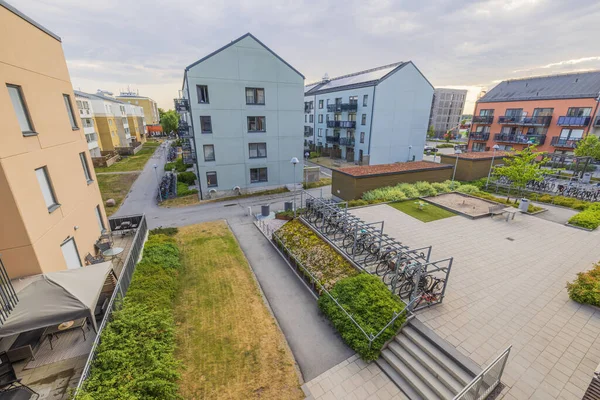Beautiful view of architecture of modern residential buildings with recreation area on playground and parking for bicycles. Sweden.