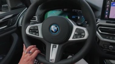 Elektrikli araba BMW iX3 M-sport 'un güzel iç manzarası yolda. Araçta kadın sürücü. 