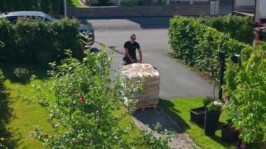 Huş ağacı yakacak odunlarını ön kapıya götüren bir işçi.. 