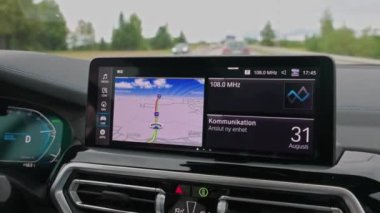 Otoyolda seyrüsefer paneli olan yeni BMW iX3 M spor elektrikli araba görüntüsü. 