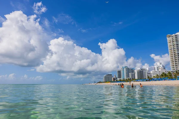 Atlantik kıyı şeridi ve Miami Plajı 'nın güzel manzarası. Mavi gökyüzünde beyaz bulutların altında yüzen insanlar var. ABD. 