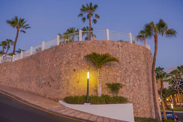 Beautiful night view of fenced mountain area with illuminated road to hotel entrance. Spain. Gran Canaria.