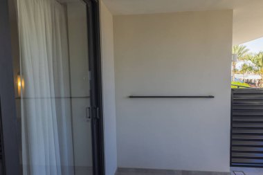 İki otel odası arasında elbise askısı olan balkon bölmesi manzarası. Curacao.