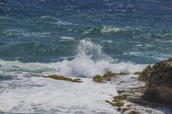Beautiful view of rocky coast of Caribbean Sea with waves crashing rocks on island of Aruba.