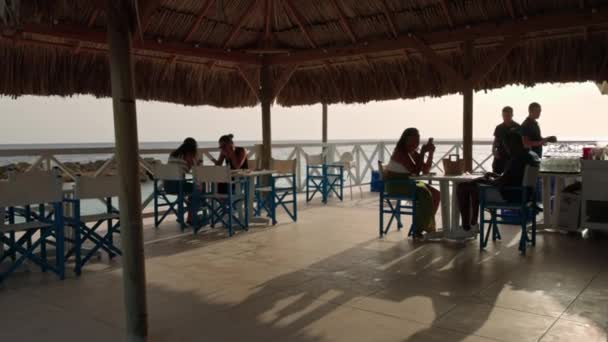 Widok Restauracji Przy Plaży Pod Krytym Strzechą Dachem Pierwszymi Gośćmi — Wideo stockowe