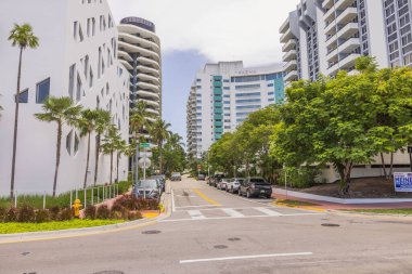 Miami Sahili 'nin güzel sokak manzarası. Her iki tarafında da park etmiş arabalar olan binalar arasında. ABD. 