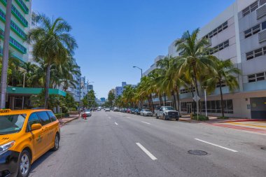 Miami Plajı 'ndaki Collins Bulvarı' nın güzel manzarası. Arabaları ve palmiye ağaçları mavi gökyüzünün arka planında. Miami Plajı. ABD. 
