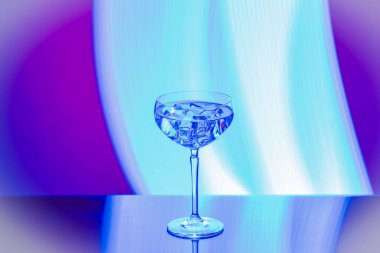 Güzel bir alkol içeceği manzarası, kristal bardakta buz küpleri ve leylak arka plan.. 