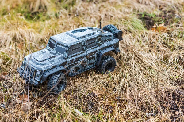 Close-up view of radio-controlled toy off-road vehicle in camouflage colors, navigating rough terrain. Sweden.