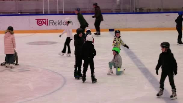 子供と大人は週末にスポーツコンプレックスでアイススケートを楽しむ — ストック動画