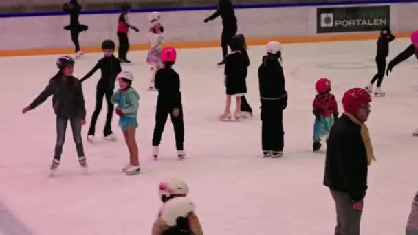 子供と大人が喜んでスケートしているスケートリンクをフィーチャーするスポーツ複合体のビュー すべての年齢のスケーターのための雰囲気を作成する — ストック動画