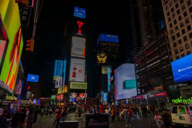 Manhattan gökdelenleri gece canlanıyor, canlı LED reklam panoları Broadway 'i aydınlatıyor ve şehrin göbeğinde ikonik kırmızı merdivenler etrafında koşuşturan bir sürü insan. - New York. ABD. 