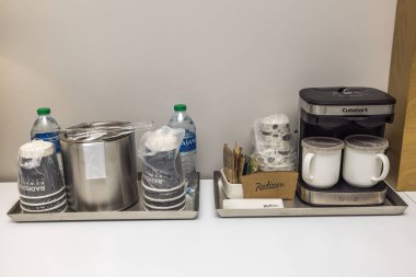 Konuk konforlarıyla dolu otel odası masası, kahve makinesi, bardak ve buz kovalı su, konforlu konaklama için rahat ve ferahlatıcı olanaklar sağlıyor. Miami Plajı. ABD. 