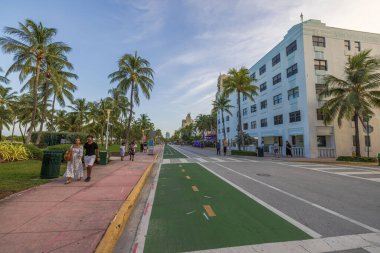 Miami Plajı 'ndaki Ocean Drive' ın güzel manzarası. İnsanlar gün batımında yaya geçidinde geziniyor. Miami Plajı. ABD. 