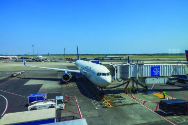 Park halindeki Delta Havayolları jetinin New York 'taki John F. Kennedy Havaalanı' ndaki biniş köprüsüne yakın görüntüsü. ABD. 